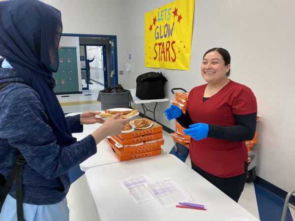 Haneen Abdelhadi, Freshman, gets served her favorite school lunch item from school support staff member, Ms. Laura Rodriguez. Pizza will continue to be served on Fridays from Little Caesars. 