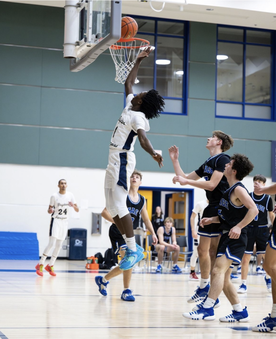 Umar Oduro, a BHA Junior, dunks the ball against the Grace Community basketball team at a varsity home game. 