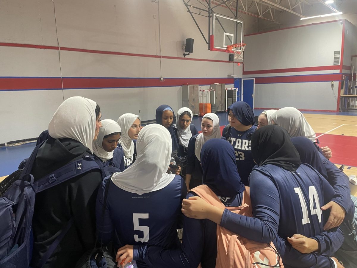 The Varsity girl’s basketball team gathers in a huddle, discussing a game plan and strategy to approach the match.
