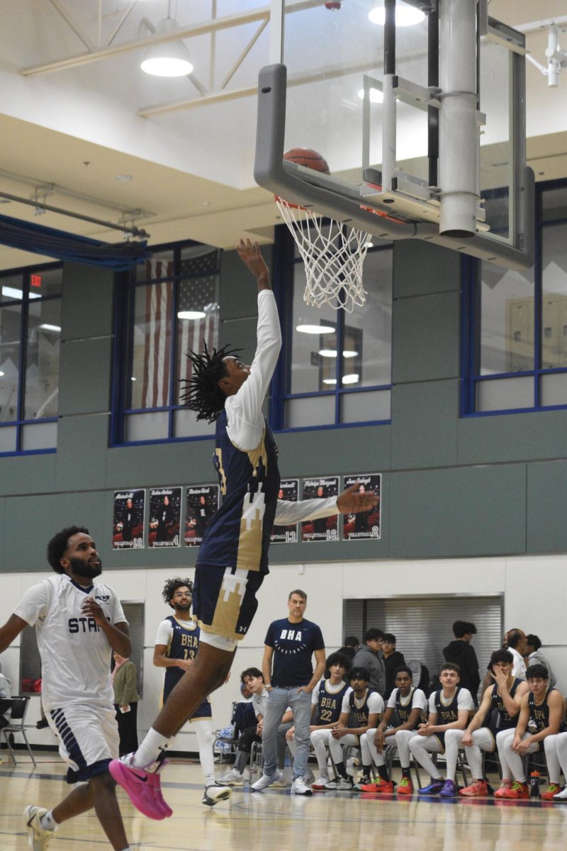 Senior Omar Oduro dunking an impressive shot during a Staff vs. Students Basketball game. (Credits: Jannah Iqbal)