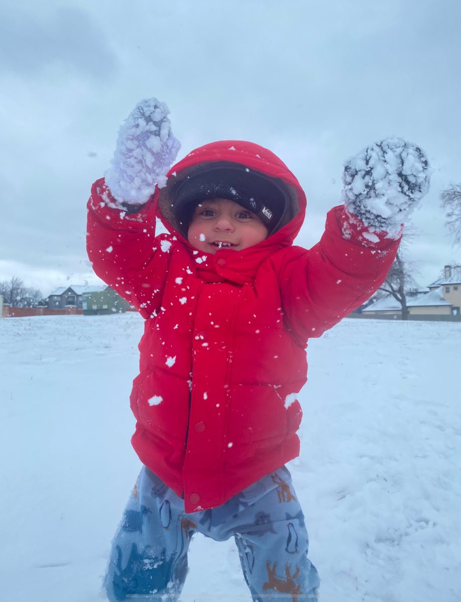 Zayd Kadiwala, an LHA student in PreK 2, plays in the snow with a big smile.