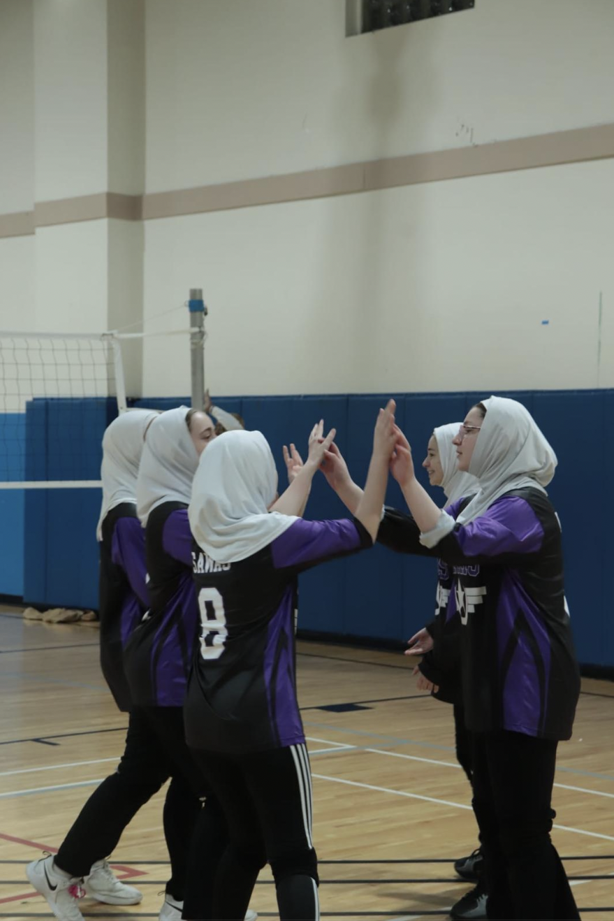 The BHA MIST Volleyball team congratulate eachother after scoring a point.