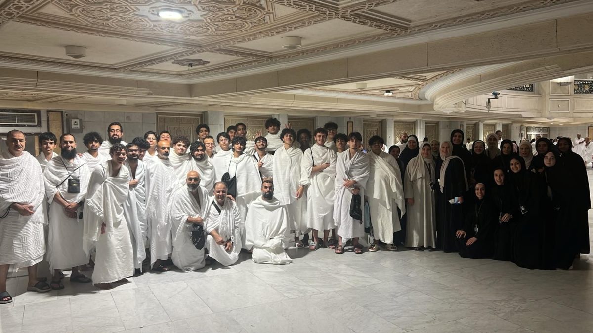Seniors pose with staff members for a group picture while on Umrah.