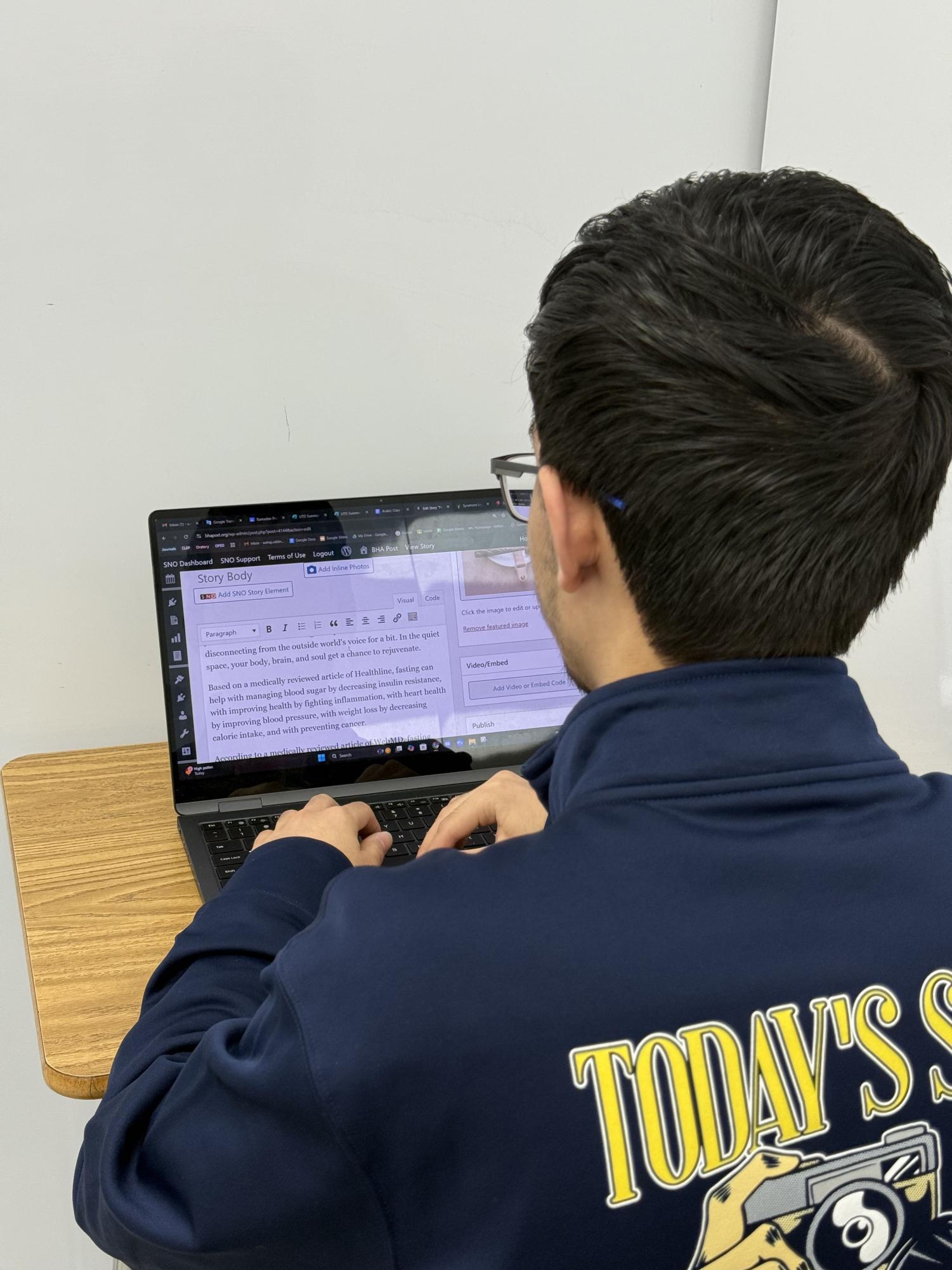 Wahaj Uddin working on editing an article for publishing.